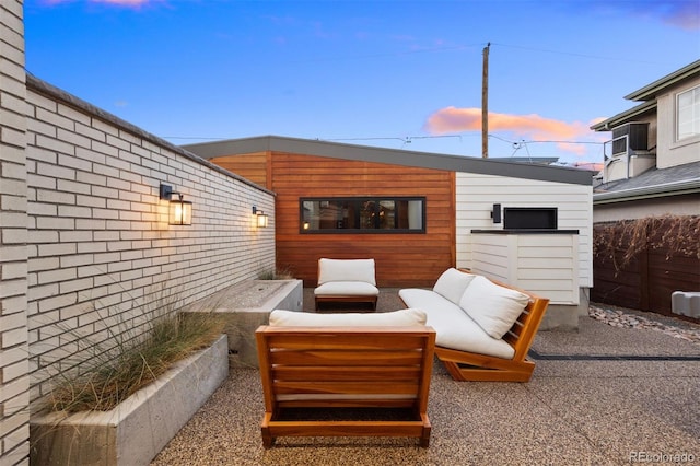 patio terrace at dusk featuring fence