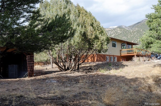 view of yard with a deck with mountain view