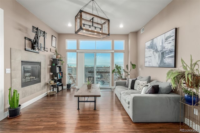 living room featuring dark wood-type flooring and a fireplace