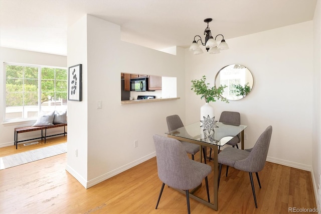 805 Summer Hawk Dr Unit 100, Longmont, CO 80504 - dining space featuring a chandelier, light wood-style floors, and baseboards