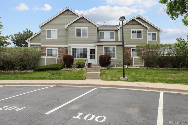 805 Summer Hawk Dr Unit 100, Longmont, CO 80504 - townhome / multi-family property featuring stone siding, uncovered parking, and a front lawn