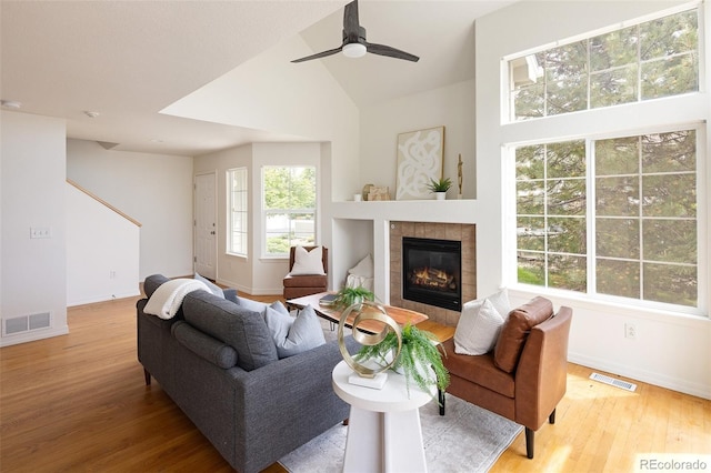 805 Summer Hawk Dr Unit 100, Longmont, CO 80504 - living area with baseboards, light wood-style floors, a tile fireplace, a ceiling fan, and lofted ceiling