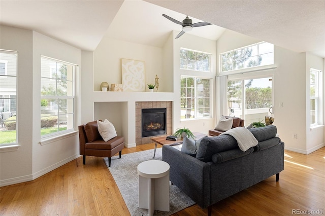 805 Summer Hawk Dr Unit 100, Longmont, CO 80504 - living room with light wood-type flooring, a fireplace, baseboards, vaulted ceiling, and a ceiling fan