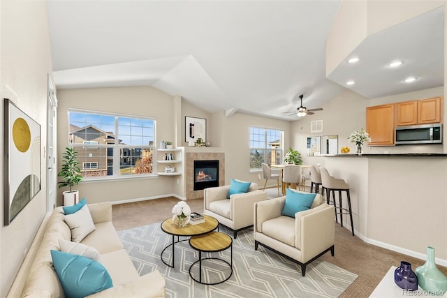 living room featuring a fireplace, ceiling fan, light carpet, and vaulted ceiling