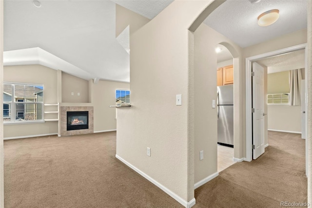 hall featuring light colored carpet and a textured ceiling