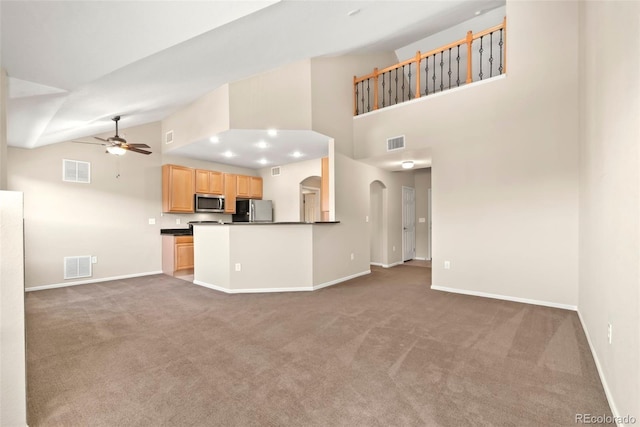 kitchen featuring carpet, high vaulted ceiling, ceiling fan, light brown cabinetry, and appliances with stainless steel finishes