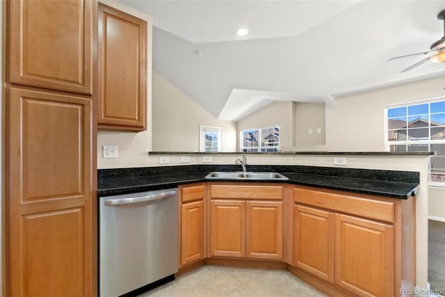 kitchen featuring dishwasher, ceiling fan, sink, and dark stone counters