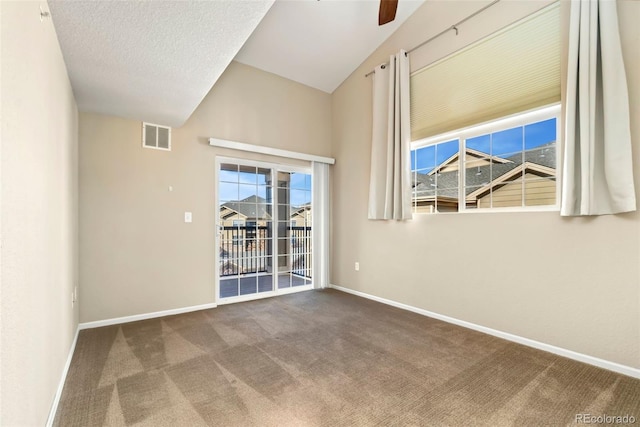 carpeted empty room with lofted ceiling, ceiling fan, a healthy amount of sunlight, and a textured ceiling