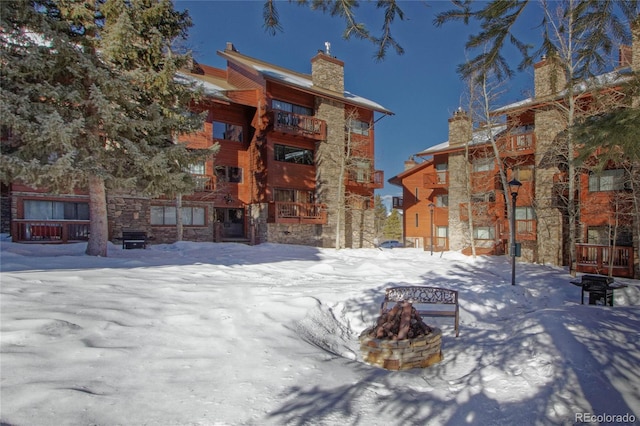 snow covered house featuring an outdoor fire pit