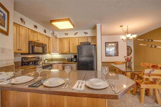 kitchen featuring kitchen peninsula, hanging light fixtures, black appliances, and an inviting chandelier