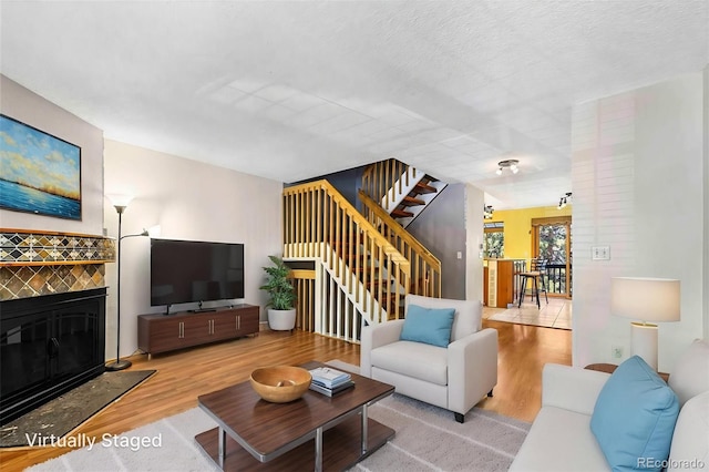 1209 S Flower Cir Unit C, Lakewood, CO 80232 - living area with stairs, wood finished floors, and a tile fireplace