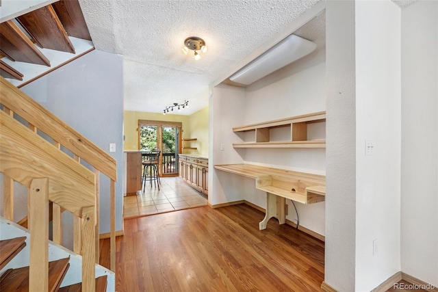 1209 S Flower Cir Unit C, Lakewood, CO 80232 - corridor featuring a textured ceiling, wood finished floors, baseboards, and rail lighting