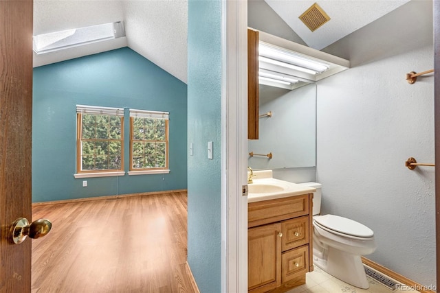 1209 S Flower Cir Unit C, Lakewood, CO 80232 - bathroom featuring lofted ceiling, a skylight, vanity, toilet, and wood finished floors