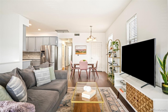 living room featuring recessed lighting, dark wood-style flooring, and visible vents