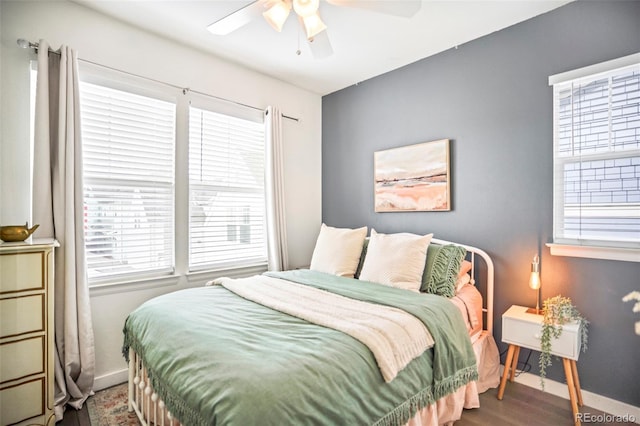 bedroom with ceiling fan, baseboards, and wood finished floors