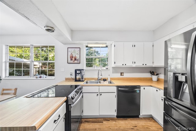 5054 W 61st Dr, Arvada, CO 80003 - kitchen with appliances with stainless steel finishes, light countertops, light wood finished floors, and white cabinetry