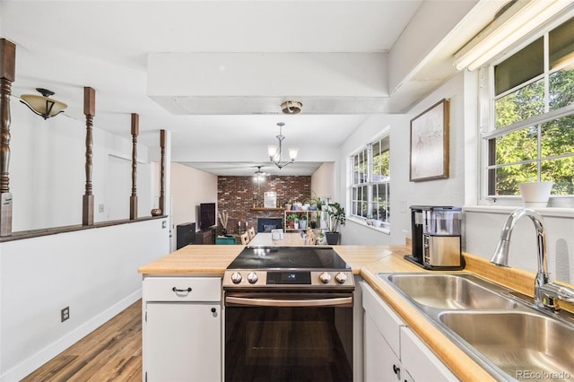 5054 W 61st Dr, Arvada, CO 80003 - kitchen with stainless steel electric stove, white cabinets, light wood-style floors, decorative light fixtures, and a chandelier