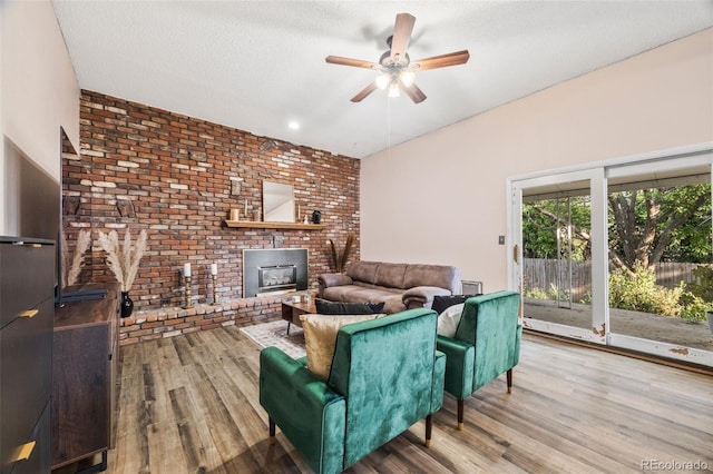 5054 W 61st Dr, Arvada, CO 80003 - living area with ceiling fan, wood finished floors, a fireplace, and brick wall