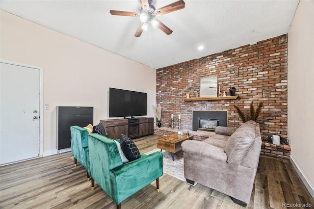 5054 W 61st Dr, Arvada, CO 80003 - living area featuring ceiling fan, wood finished floors, brick wall, a fireplace, and a textured ceiling