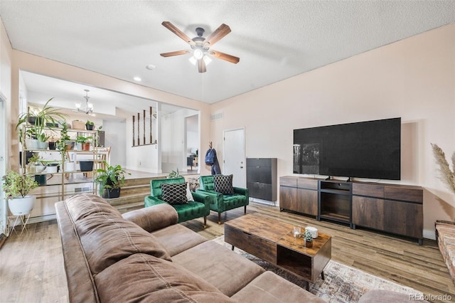5054 W 61st Dr, Arvada, CO 80003 - living room with light wood-type flooring, a ceiling fan, a chandelier, and a textured ceiling