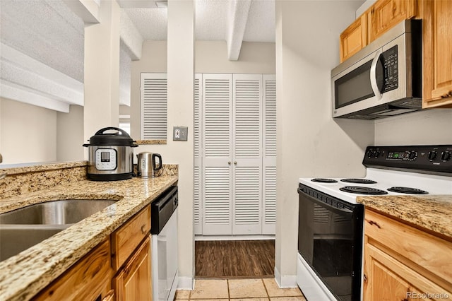 1365 Columbine St Unit 403, Denver, CO 80206 - kitchen featuring range with electric cooktop, stainless steel microwave, dishwasher, a textured ceiling, and light stone counters