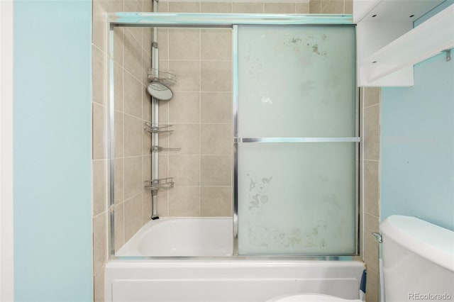 bathroom with toilet and bath / shower combo with glass door