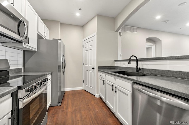 kitchen featuring stainless steel appliances, white cabinetry, tasteful backsplash, and sink