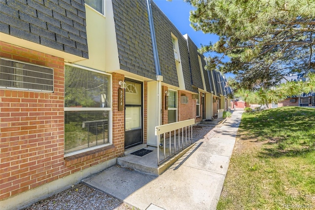 5828 S Pearl St, Centennial, CO 80121 - property entrance with brick siding, mansard roof, and roof with shingles