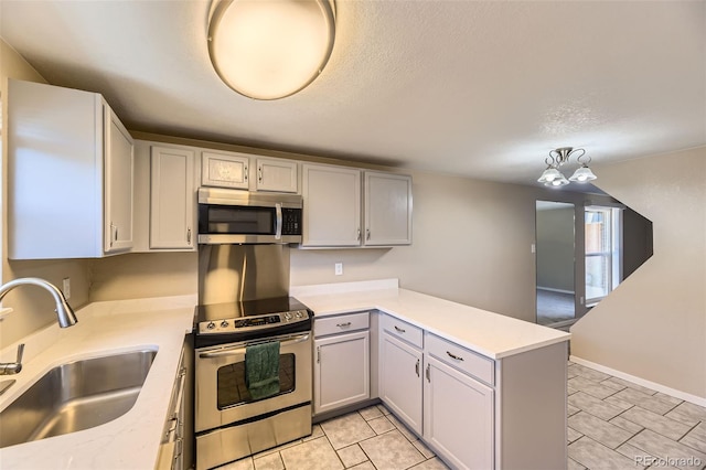 5828 S Pearl St, Centennial, CO 80121 - kitchen featuring appliances with stainless steel finishes, light countertops, a peninsula, gray cabinetry, and a textured ceiling