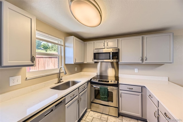 5828 S Pearl St, Centennial, CO 80121 - kitchen with appliances with stainless steel finishes, gray cabinetry, light countertops, light tile patterned flooring, and a textured ceiling