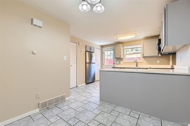 5828 S Pearl St, Centennial, CO 80121 - kitchen with stainless steel appliances, a peninsula, light countertops, and light tile patterned floors