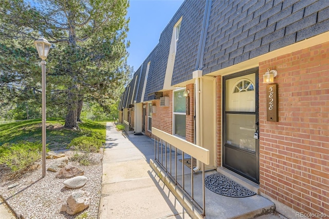 5828 S Pearl St, Centennial, CO 80121 - view of exterior entry with a shingled roof, brick siding, and mansard roof