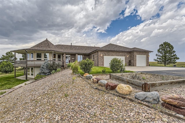 view of front of property with brick siding, an attached garage, concrete driveway, and roof with shingles