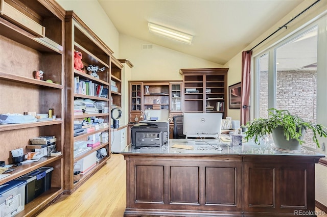 office area with visible vents, light wood-style flooring, and vaulted ceiling