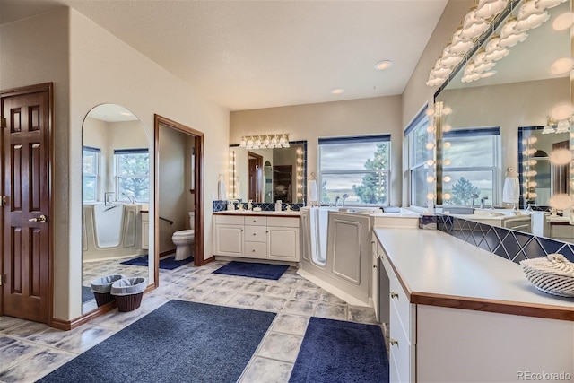 full bathroom featuring vanity, toilet, a tub, and tile patterned flooring