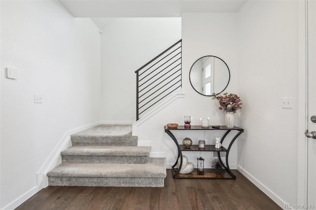 stairway with wood finished floors and baseboards