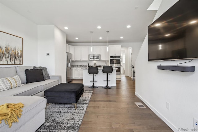 living room featuring visible vents, recessed lighting, dark wood-style flooring, and baseboards