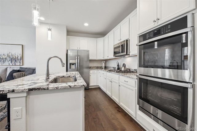 kitchen with dark wood-style flooring, white cabinets, stainless steel appliances, and a sink