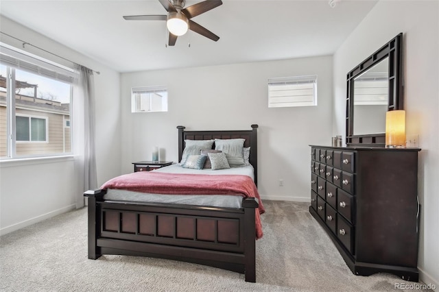 bedroom featuring light colored carpet, baseboards, and ceiling fan