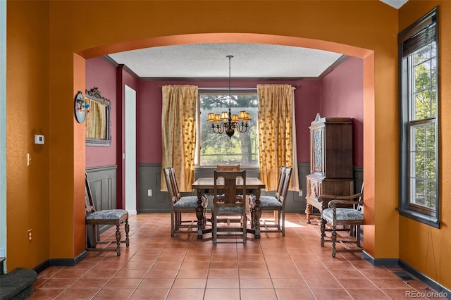 10519 Winterflower Way, Parker, CO 80134 - tiled dining space featuring a textured ceiling, baseboards, a chandelier, crown molding, and arched walkways