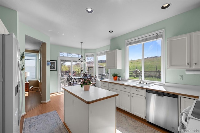 10519 Winterflower Way, Parker, CO 80134 - kitchen with white fridge with ice dispenser, dishwasher, light wood finished floors, a sink, and light countertops