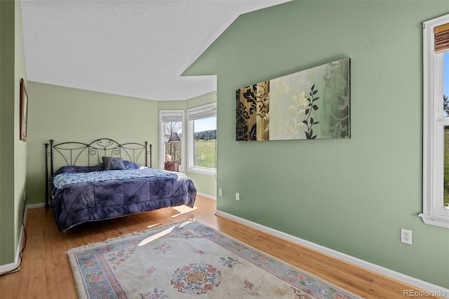 10519 Winterflower Way, Parker, CO 80134 - bedroom featuring baseboards, vaulted ceiling, and wood finished floors