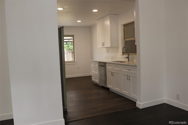 kitchen with dark hardwood / wood-style floors, sink, white cabinetry, decorative backsplash, and stainless steel dishwasher