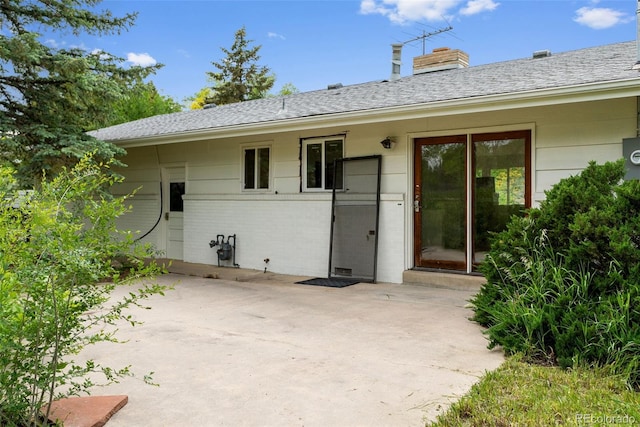 7313 S Boulder Rd, Boulder, CO 80303 - entrance to property with a patio area, brick siding, a chimney, and a shingled roof