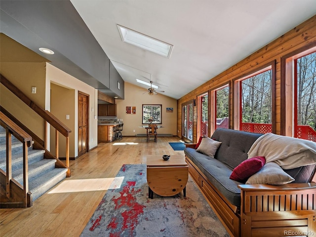10852 Conifer Mountain Rd, Conifer, CO 80433 - living area with a skylight, vaulted ceiling, light wood-style floors, stairway, and baseboard heating