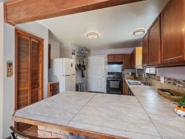 10852 Conifer Mountain Rd, Conifer, CO 80433 - kitchen featuring black range with electric stovetop, freestanding refrigerator, a sink, extractor fan, and a peninsula