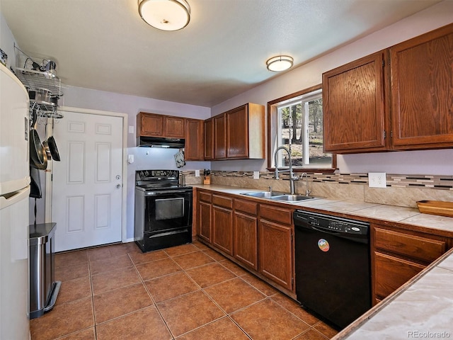 10852 Conifer Mountain Rd, Conifer, CO 80433 - kitchen with black appliances, a sink, under cabinet range hood, tile counters, and tile patterned floors
