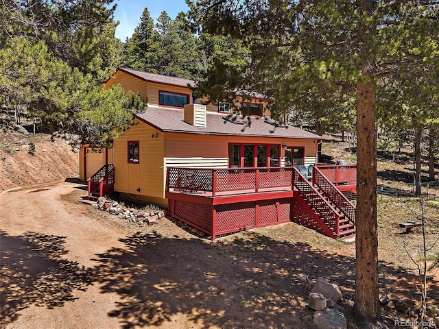 10852 Conifer Mountain Rd, Conifer, CO 80433 - rear view of property with a wooden deck, stairway, roof with shingles, and driveway