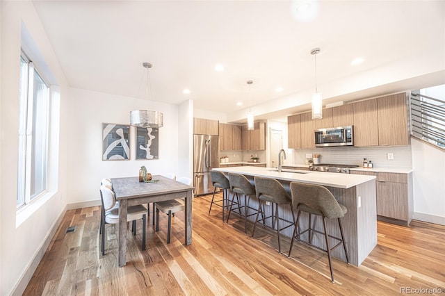 822 Fairfax St, Denver, CO 80220 - kitchen featuring stainless steel appliances, modern cabinets, a kitchen breakfast bar, light countertops, and recessed lighting
