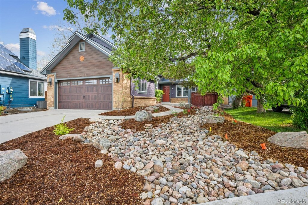 10729 Kipling Way, Broomfield, CO 80021 - view of front of house with concrete driveway, brick siding, an attached garage, and central AC